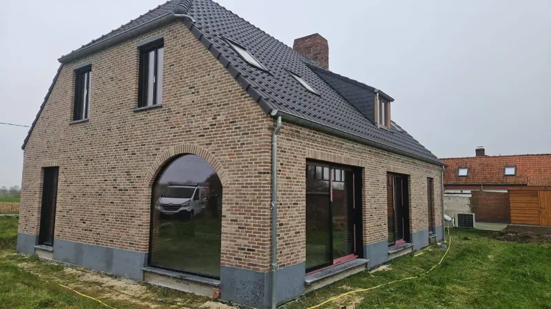 Gevelrenovatie en voegwerken van woning met boogvenster in West-Vlaanderen