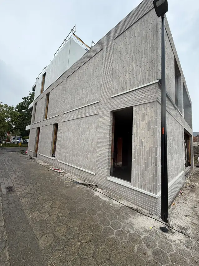 Nieuw appartementsgebouw in lichtgrijze baksteen in Desselgem na het voegen