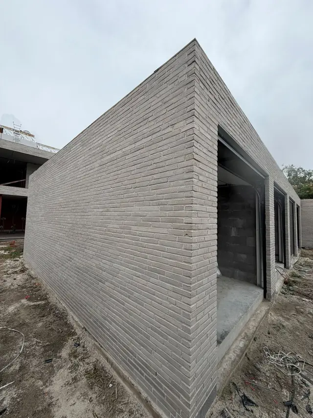 Afgewerkte hoek van het appartementsgebouw in Desselgem in lichtgrijze baksteen