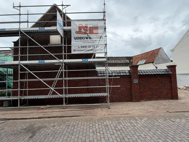 Woning in de stelling met een spandoek van NS Voegwerken, tijdens de gevelrenovatie