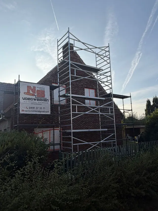 Stelling met het doek van NS Voegwerken tegen de puntgevel in Kuurne