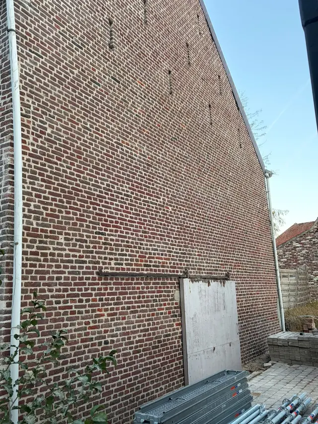 Hoge zijgevel in oude rode baksteen in Lauwe na het hervoegen