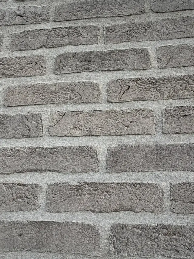 Detail van grijze baksteen met lichte voegen van de nieuwbouw in Lendelede