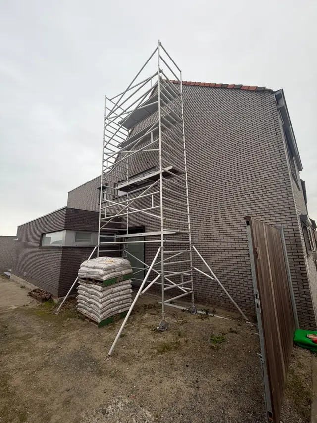 Stelling tegen de zijgevel van de nieuwbouw in Lendelede tijdens het voegen