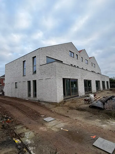 Rij moderne nieuwbouwwoningen in lichtgrijze baksteen
