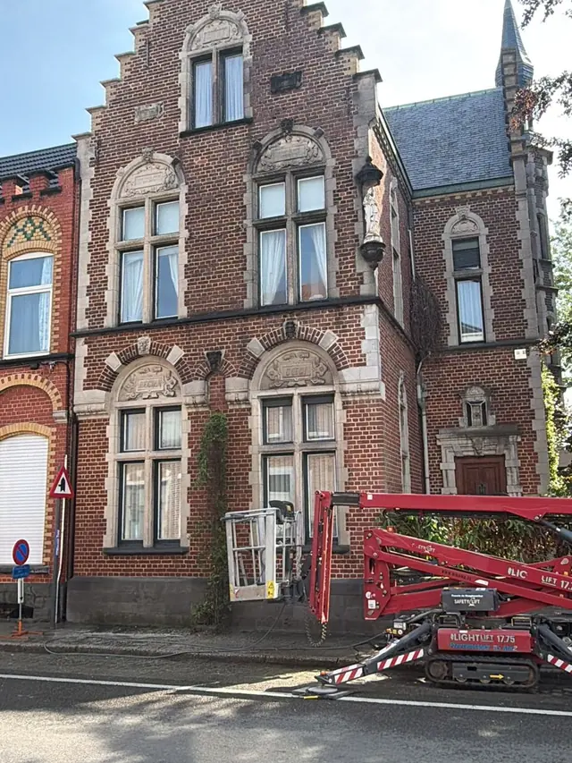 Herenhuis met trapgevel in Roeselare voor de gevelreiniging, met een hoogtewerker ervoor