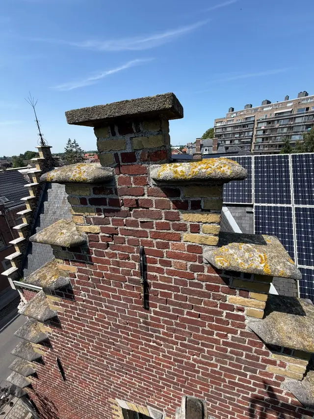 Top van de trapgevel met mos op de afdekstenen, voor de reiniging