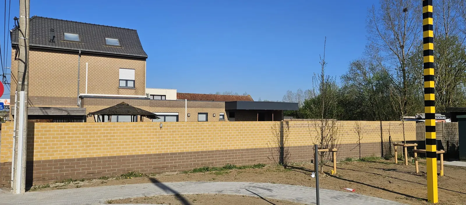 Dezelfde tuinmuur na de reiniging en de hydrofugebehandeling