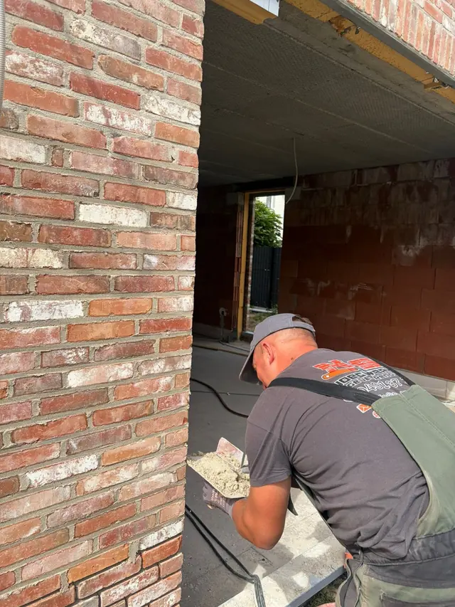 Voeger van NS Voegwerken aan het werk op een nieuwbouwwerf in Moorslede