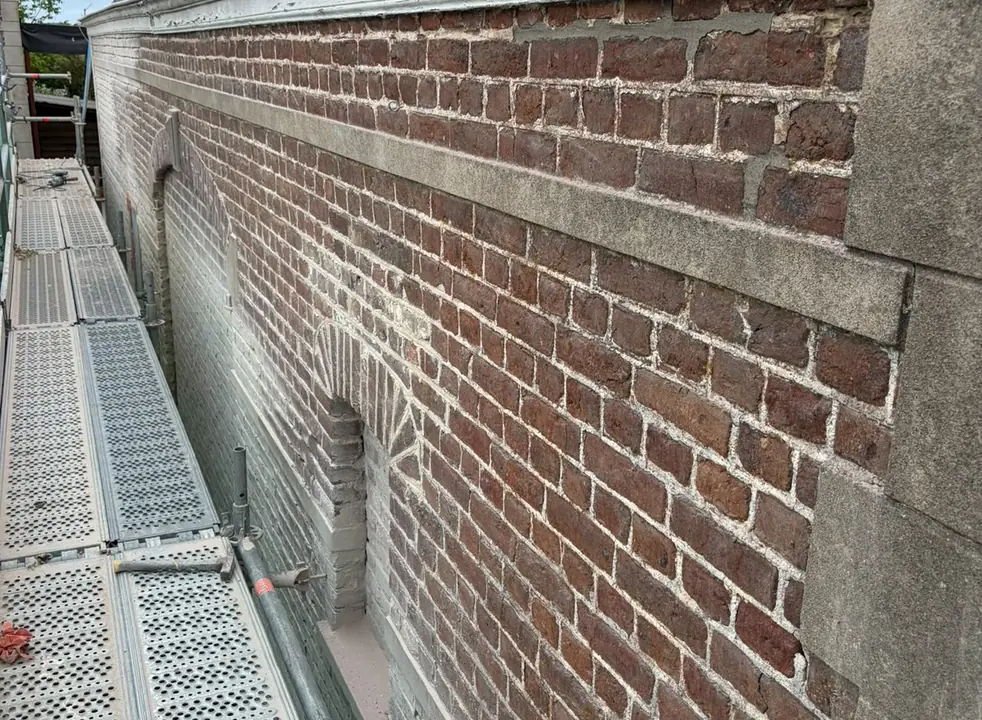 Dezelfde zijgevel na het zandstralen, met de rode baksteen weer zichtbaar