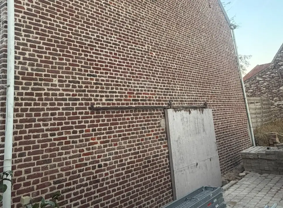 Dezelfde zijgevel na het uitslijpen, reinigen en opnieuw voegen